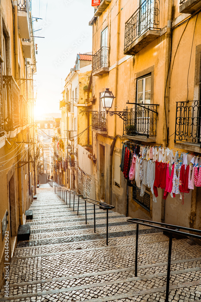 Staircase in the cobblestone street in Lisbon. Hanging laundry in typical narrow street. Sunset in the old downtown of Lisbon, impressions of the city. Lissabon