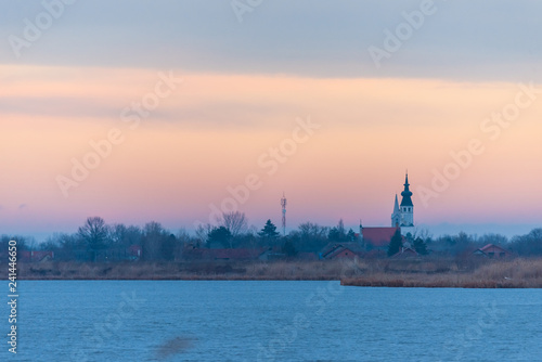 Fototapeta Naklejka Na Ścianę i Meble -  two churches in the village by the lake