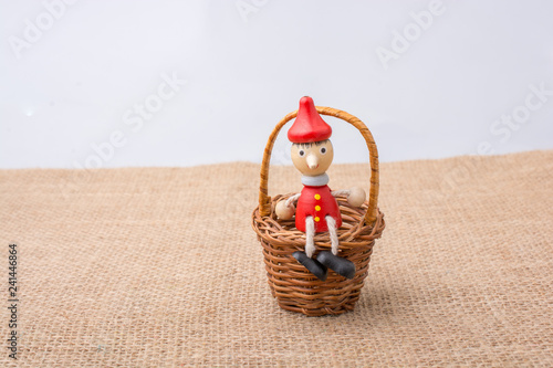 Wooden Pinocchio doll sitti...
