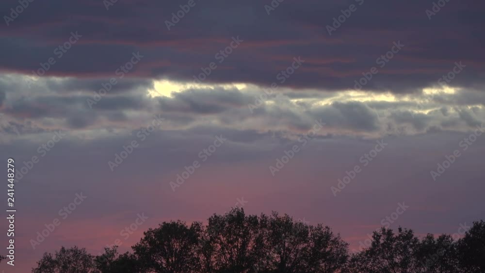 RAIN CLOUDS ARE WINDOWS IN THE PINK SKY AT SUNSET. RAIN CLOUDS ARE WINDOWS IN THE PINK SKY AT SUNSET.