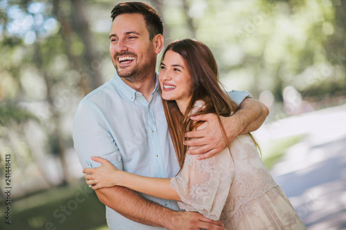 Cheerful young couple having fun and laughing together outdoors, selective focus