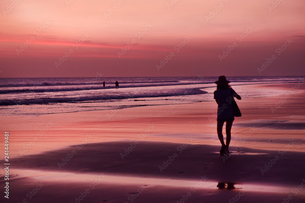 Tourist girl taking the photos of Kuta Beach in sunset, Bali Island, Indonesia