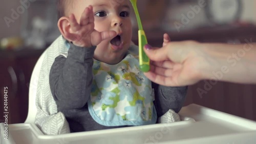 Mom give spoon baby child infant in high chair kitchen weaning solids independent toddler