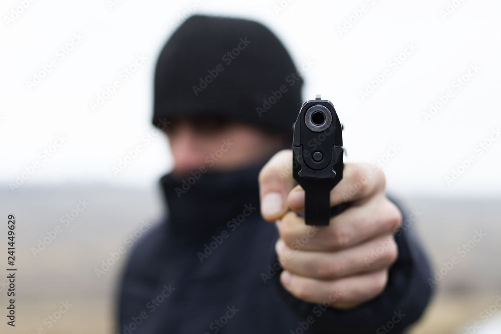 Man shooting from a gun, robber commits a crime, criminal concept Man shooting from a gun, robber commits a crime, criminal concept