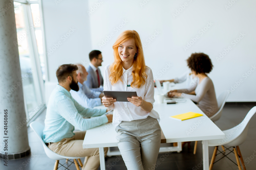 Pretty young red hair woman using digital tablet