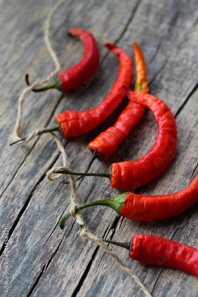 Dried red chili peppers on an old wooden background with a place for text. An overview of chili chip on an old wooden table. Style of minimalism. Dried red chili peppers on an old wooden background with a place for text. An overview of chili chip on an old wooden table. Style of minimalism.