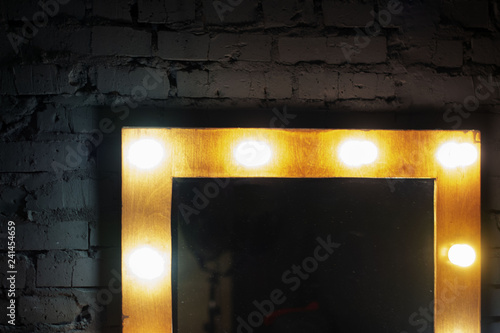 Makeup mirror in photo studio with blured lighting bulbs