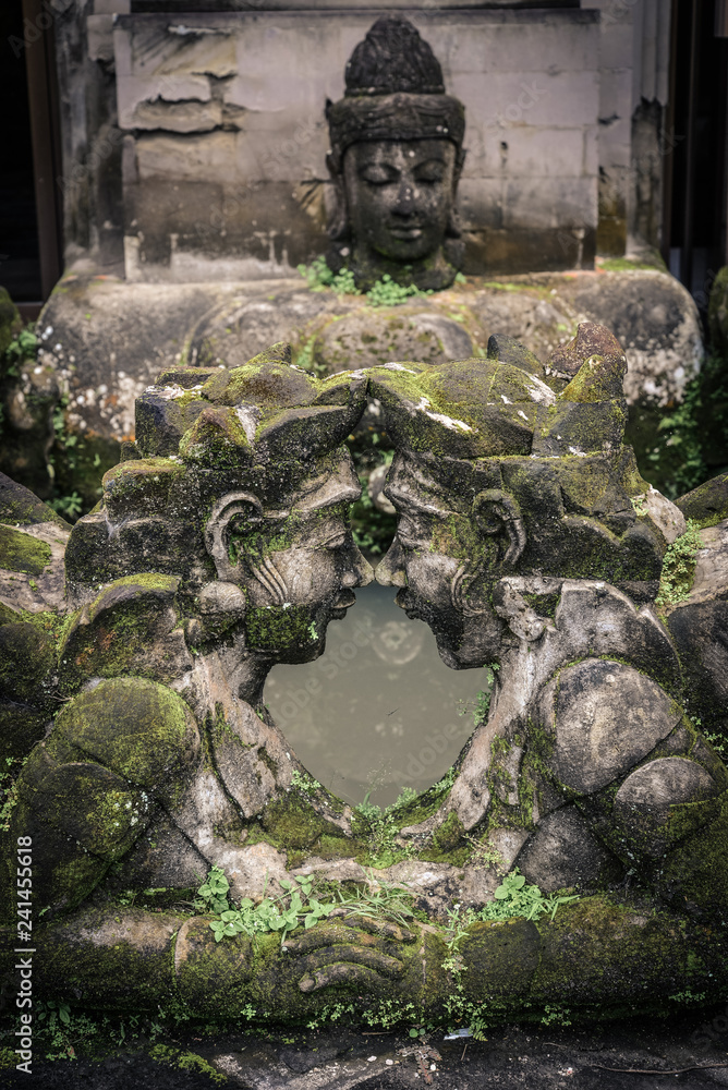 Traditional balinese stone sculpture of a man and woman with moss Traditional balinese stone sculpture of a man and woman with moss