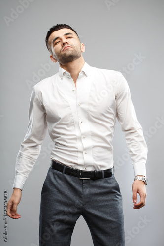 Handsome casual man standing relaxed  isolated on a gray background. © ksi