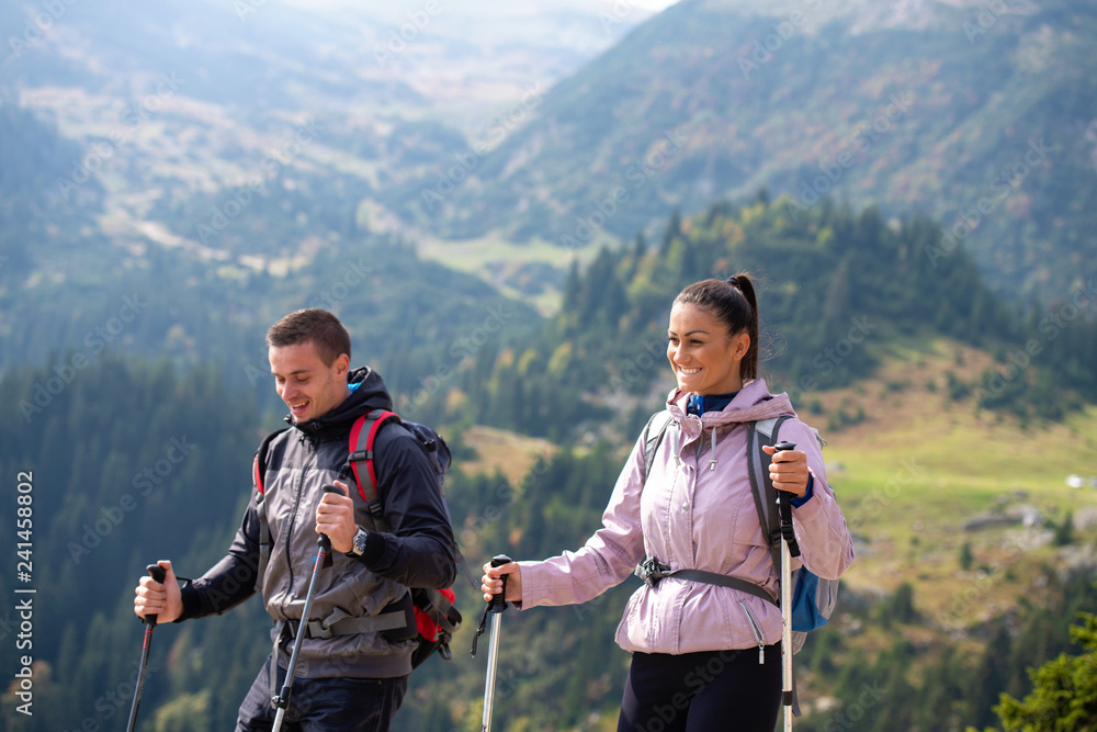 Portrait of happy couple hiking in the countryside at summer