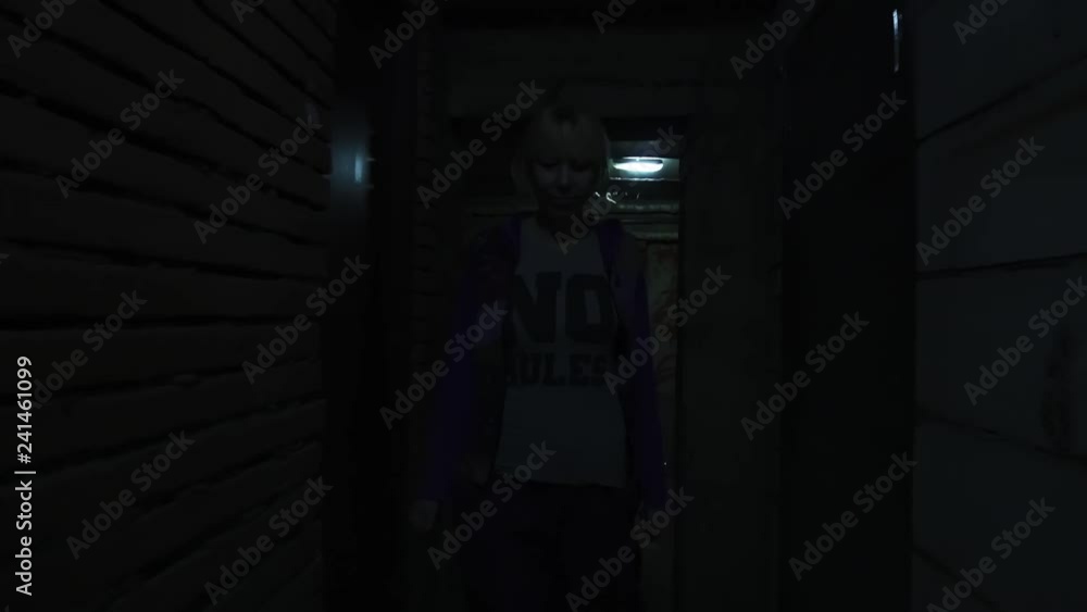 Woman moving in dark gloomy basement corridor Woman moving in dark gloomy basement corridor