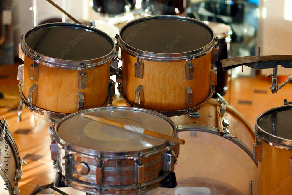 Drum set illuminated by the rays of the setting sun in a music studio. Closeup. Drum set illuminated by the rays of the setting sun in a music studio. Closeup.