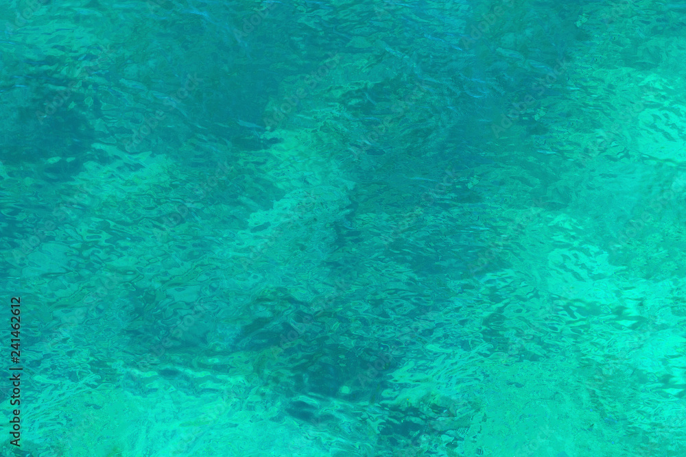 Clear turquoise sea water with a view of the bottom.