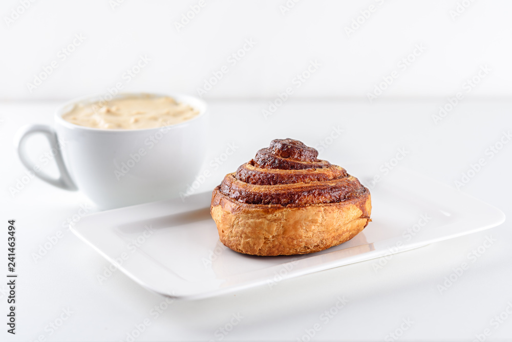 Perfect morning,sweet breakfast and start day.Coffee cup and Cinnamon Danish Swirl-classic buttery danish pastry rolled with cinnamon and glazed with sugar on dish on white background. Perfect morning,sweet breakfast and start day.Coffee cup and Cinnamon Danish Swirl-classic buttery danish pastry rolled with cinnamon and glazed with sugar on dish on white background.