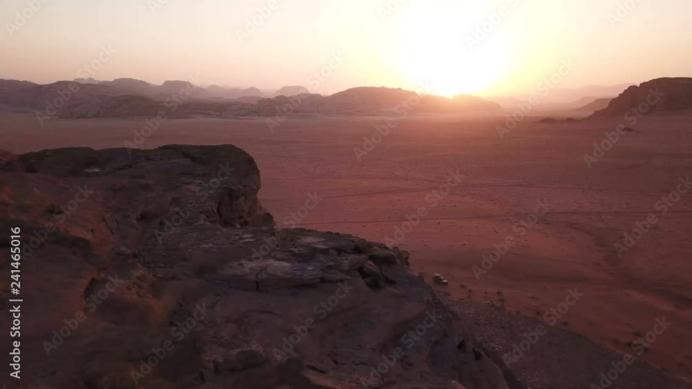 Drone flying over desert mountains with adventure 4WD off road cars parked in sand