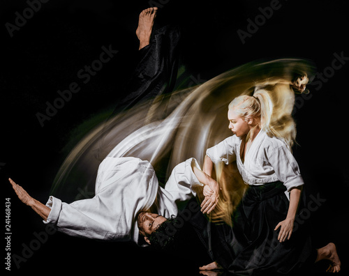 two bodokas fighters man and woman practicing Aikido studio shot isolated on black background photo