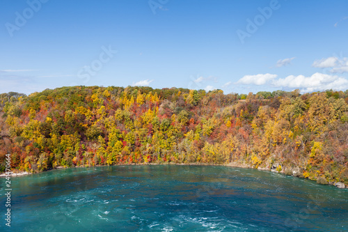 Niagara Whirlpool. The view across Niagara Whirlpool located on the Canadian and American border. In the background can be seen the colorful foliage of trees during the fall.