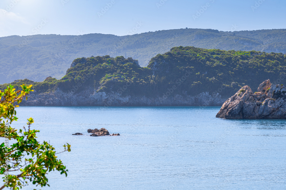 Beautiful summer panoramic seascape. View of the cliff into the sea bay with crystal clear azure water in sunshine daylight. Boats and yachts in the harbor. Mediterranean sea, somewhere in Europe.