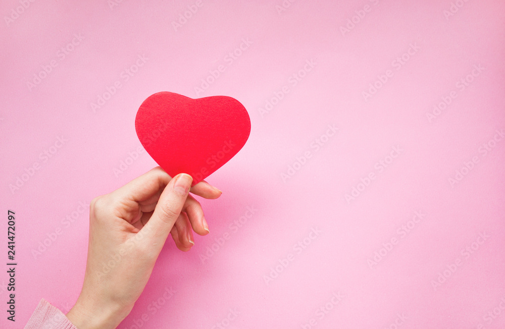 Woman hand holding a heart shape card. Woman hand holding a heart shape card.