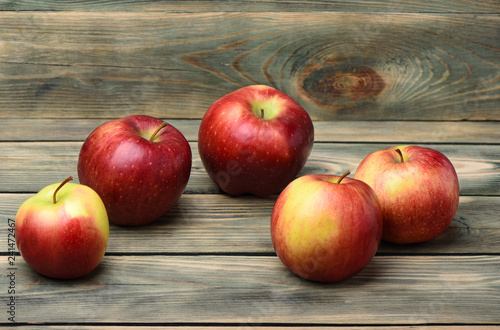 Several ripe apples on a wooden background
