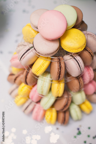 Фотография colorful french macarons multilevel cake pyramid on plastic dessert stand