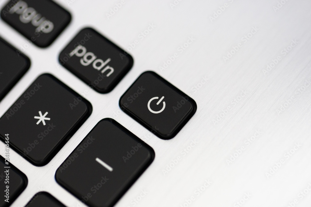 close up laptop keyboard part. Black key power on a light silver scratched texture background. concept it and business. soft focus. copy space close up laptop keyboard part. Black key power on a light silver scratched texture background. concept it and business. soft focus. copy space