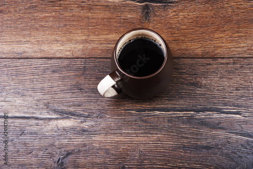 Mug with black coffee on a wooden table