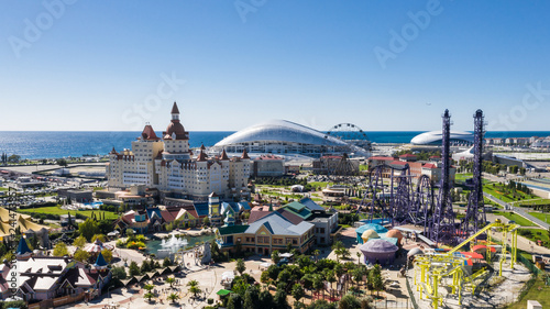 RUSSIA, SOCHI - JUL 27, 2018: Amusement park near hotel Bogatyr at summer sunny day. Aerial view. Photo with noise from action camera
