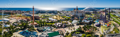RUSSIA, SOCHI - JUL 27, 2018: Amusement park near hotel Bogatyr at summer sunny day. Aerial view. Photo with noise from action camera photo