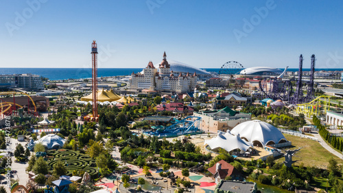 RUSSIA, SOCHI - JUL 27, 2018: Amusement park near hotel Bogatyr at summer sunny day. Aerial view. Photo with noise from action camera