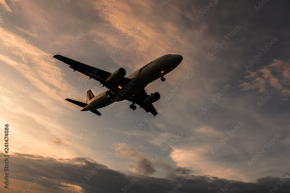 In the evening the airplane is landing overhead In the evening the airplane is landing overhead