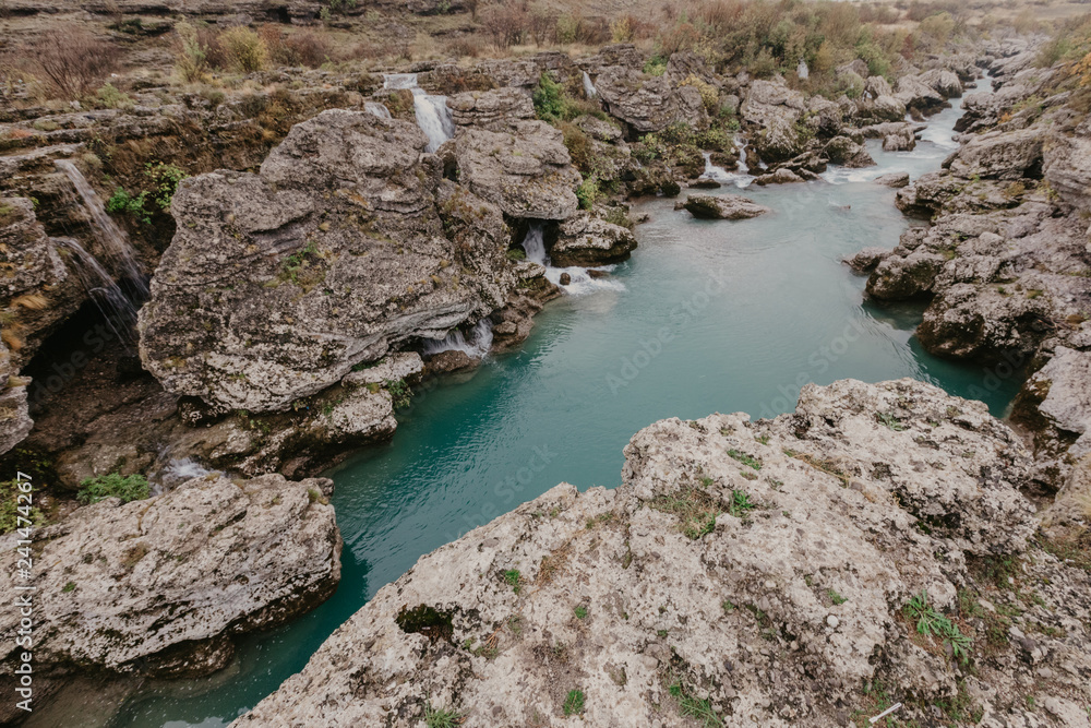 Mountain river with huge, big, and small stones and rocks on riverbed. Mountain river with huge, big, and small stones and rocks on riverbed.