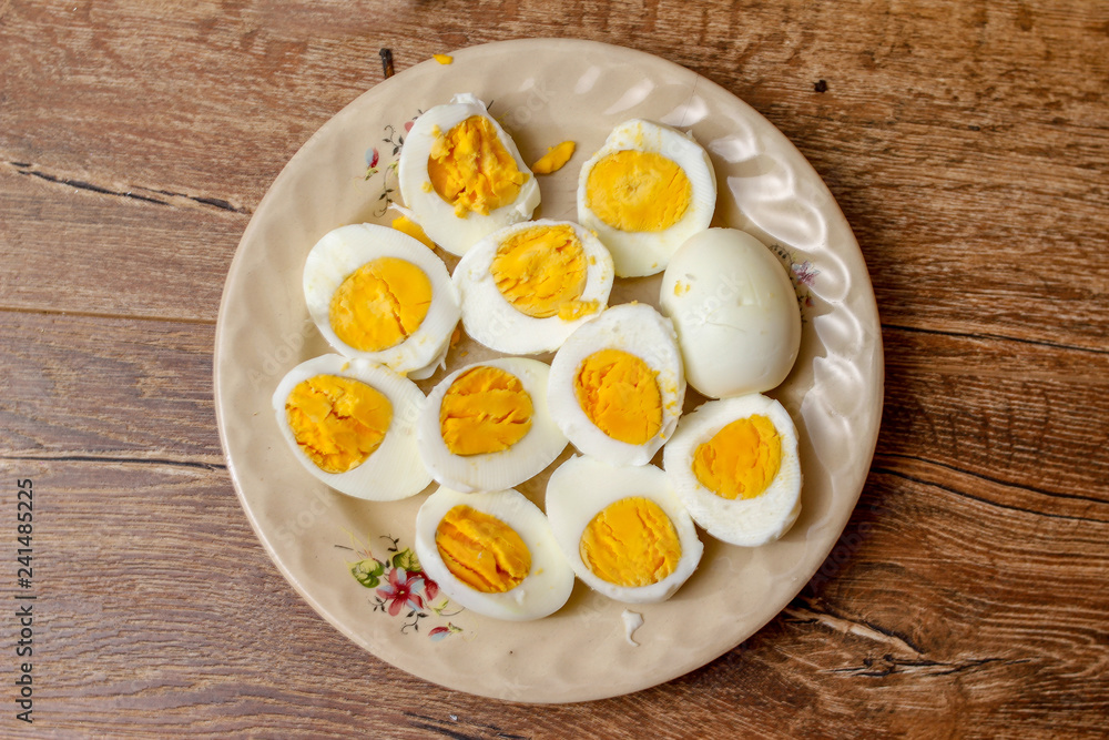 Hard boiled chicken eggs in a porcelain plate on vintage wooden table Hard boiled chicken eggs in a porcelain plate on vintage wooden table