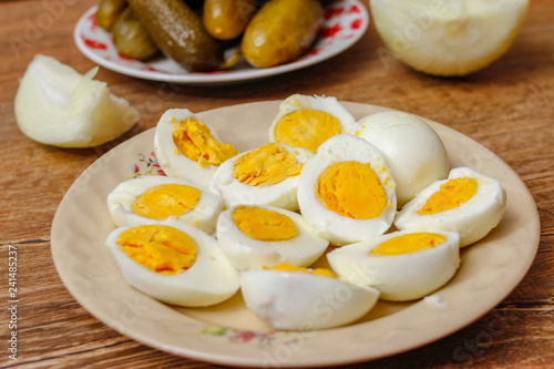 Hard boiled chicken eggs in a porcelain plate on vintage wooden table