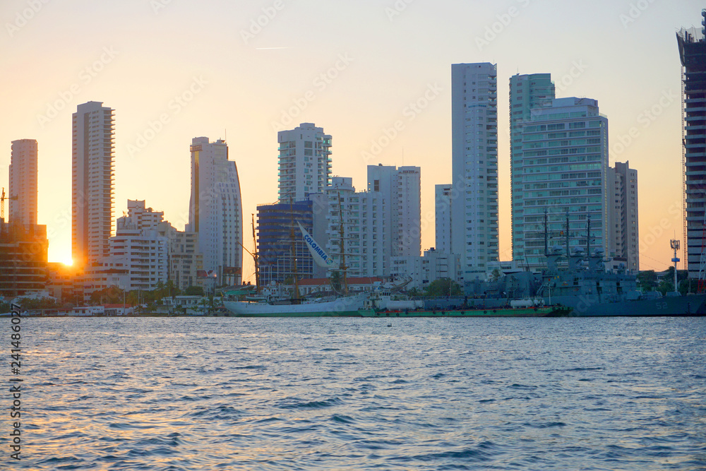 Fototapeta premium Cartagena / Colombia - 12 25 2018: Panoramic view of the coastline of the city and the sea with blue sky with some boats or ships with a sunset and buildings