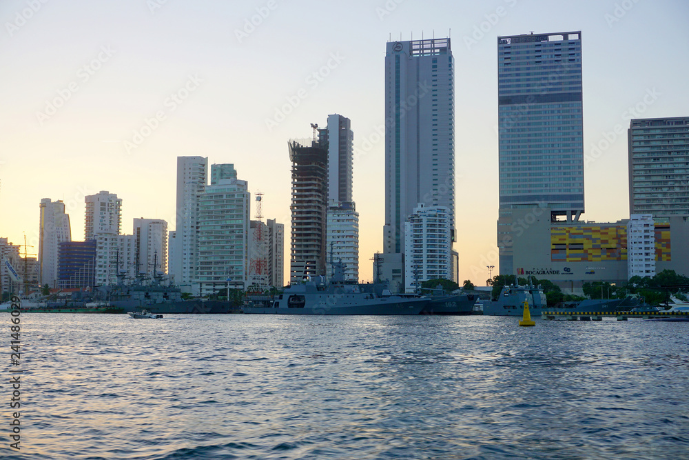 Obraz premium Cartagena / Colombia - 12 25 2018: Panoramic view of the coastline of the city and the sea with blue sky with some boats or ships with a sunset and buildings