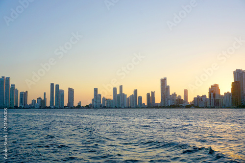 Cartagena / Colombia - 12 25 2018: Panoramic view of the coastline of the city and the sea with blue sky with some boats or ships with a sunset and buildings