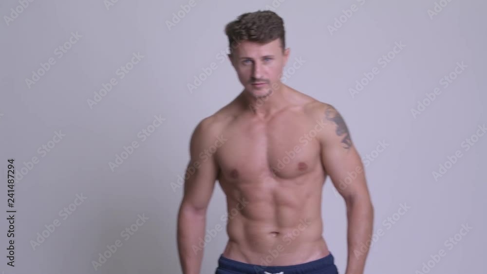 Muscular handsome bearded man with shooting gesture at camera shirtless Muscular handsome bearded man with shooting gesture at camera shirtless