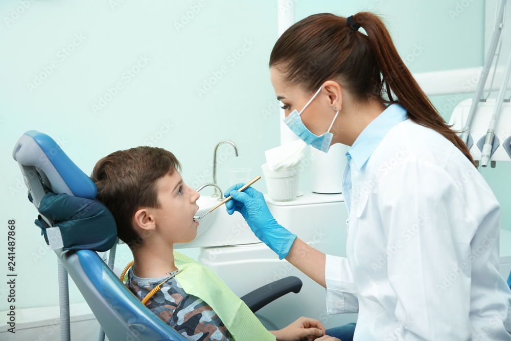 Professional dentist working with little patient in modern clinic Professional dentist working with little patient in modern clinic
