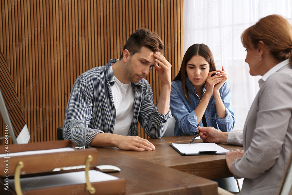 Lawyer having meeting with young couple in office Lawyer having meeting with young couple in office