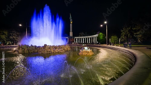 Night view of the colorful fountain at Schwarzenbergplatzin Vienna, Austria with the Soviet War Memorial in the background.