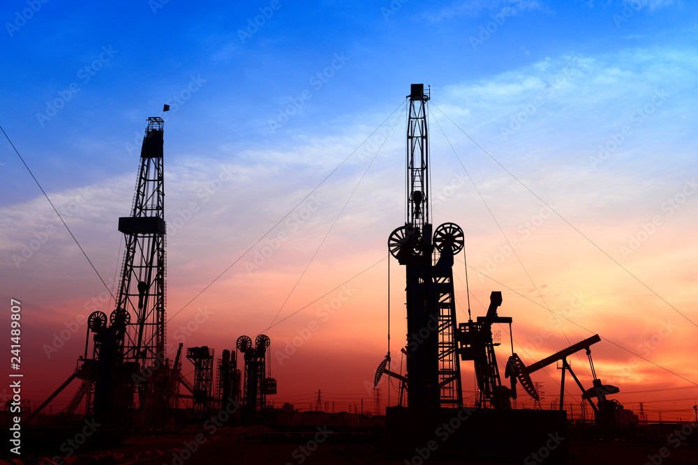 The pumping unit is at work in the evening of the oilfield The pumping unit is at work in the evening of the oilfield