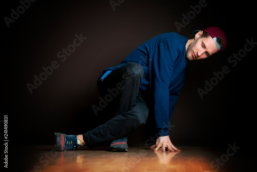 closeup photo of male break dancer performing stance against dark background b