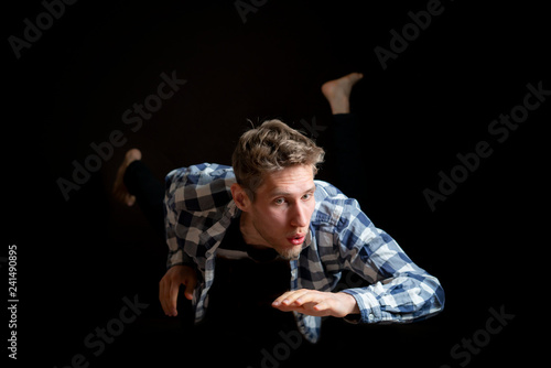 Vászonkép handsome young male levitate in air on dark background b