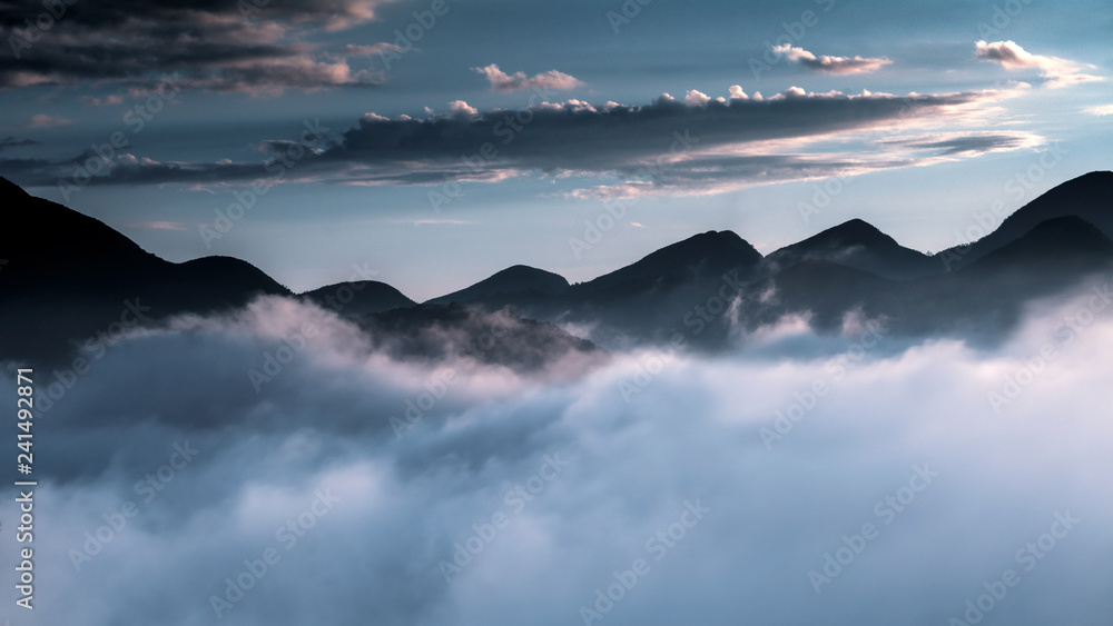 Naklejka premium Chain of mountains in Itaipava, Rio de Janeiro, Brazil, featuring dense fog that looks like clouds