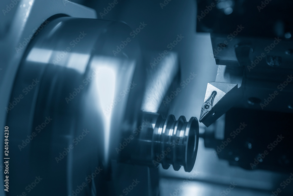 The CNC lathe or turning machine cutting the slot at the metal part.Hi-technology manufacturing process. The CNC lathe or turning machine cutting the slot at the metal part.Hi-technology manufacturing process.
