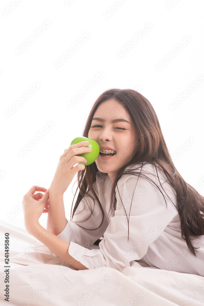 Beautiful asian woman wearing white shirt with holding green apple isolated on white background Beautiful asian woman wearing white shirt with holding green apple isolated on white background