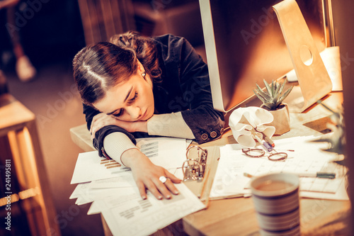 Exhausted young woman putting her head on arm