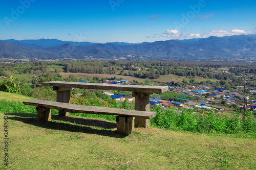 Wooden bench on the top of high hills. Background blue sky and mountain.