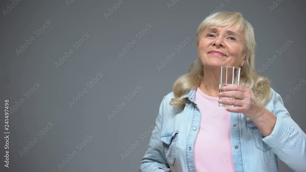 Elderly woman surprised with taste of pill taking it with relief, healthcare Elderly woman surprised with taste of pill taking it with relief, healthcare